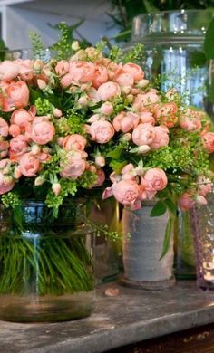 several vases filled with pink flowers and greenery