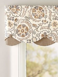 a window with a flowered valance hanging from it's side