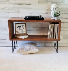 a wooden shelf with some records on it and a record player sitting on top of it