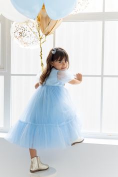 Bring the magic of Elsa to life with our enchanting Blue Satin Maxi Tulle Dress, perfect for any little one who dreams of becoming a princess. The elegant design, inspired by Frozen's beloved Elsa, features a square neckline, puff sleeves, and a flowing tulle skirt that captures the spirit of a royal winter wonderland. The delicate pearl button detailing on the back adds a sophisticated touch, making this dress perfect for birthdays, special events, or imaginative play. Design Features: The dress features a square neckline and short puff sleeves, creating a regal and timeless silhouette. The back is detailed with pearl buttons, adding a touch of elegance reminiscent of a true princess. Comfort & Material: The dress is lined with 100% cotton for comfort, while the outer layer is made of lux Frozen Blue, Long Tutu, Frozen Theme Party, Tulle Maxi Skirt, Dress For Girls, Satin Maxi, Blue Satin, Tutu Dress, Imaginative Play