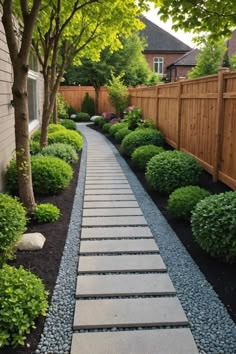 a stone path in the middle of a yard with trees and bushes on either side