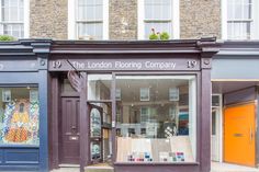 the london flooring company is located in an old brick building with many windows and doors