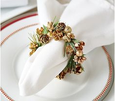 the napkin is decorated with pine cones and gold flowers