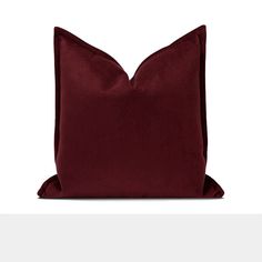 a red pillow on a white surface