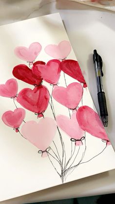 an art project with watercolors on paper and hearts in the shape of balloons