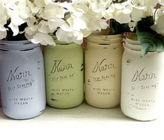 some jars are sitting on a shelf with flowers in the middle and one is labeled dissessed shabby chic