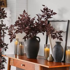 a wooden table topped with vases filled with plants