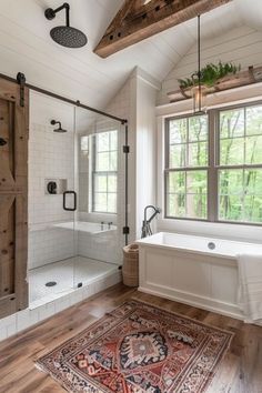 a bathroom with a rug, tub and window