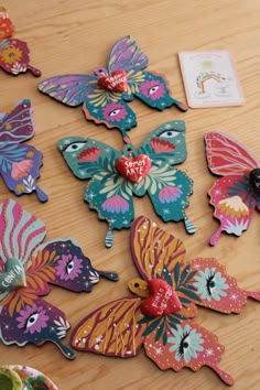 many colorful butterflies on a wooden table