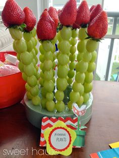 some grapes and strawberries are arranged on a table