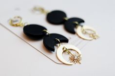 three pairs of black and white earrings on top of a piece of paper next to each other