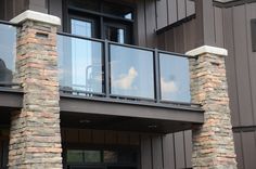 a balcony with stone pillars and glass balconies