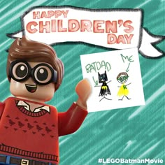 a lego character holding up a sign that says happy children's day with an image of a cat