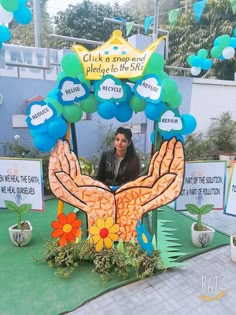 a woman standing in front of a table with flowers and balloons