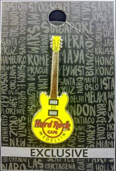 a yellow guitar shaped keychain sitting on top of a card