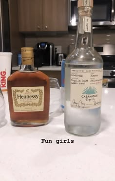 two bottles of liquor sitting on top of a counter