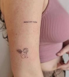 a woman with a small tattoo on her arm that says mind over matter and an angel