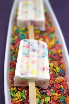 two popsicles are sitting in a boat filled with cereal