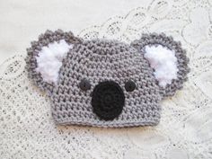 a crocheted koala hat is laying on a bed