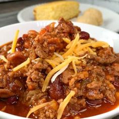 a white bowl filled with chili and cheese