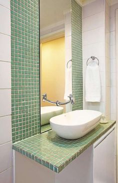 a bathroom sink sitting under a mirror next to a towel rack