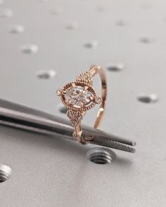 a diamond ring sitting on top of a pair of scissors