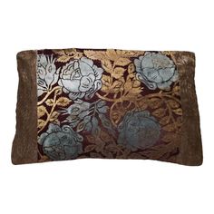 a brown and blue pillow with flowers on it