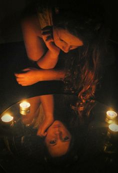 two women are reflected in a table with candles