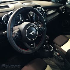 the interior of a small car with black and red trims