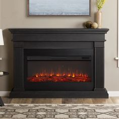 an electric fireplace in a living room with a painting on the wall above it and a rug