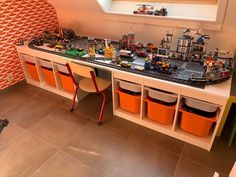 a toy train table with legos on it and two chairs in front of it