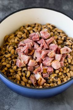 ham and beans in a blue bowl on a gray countertop with black - eyed peas