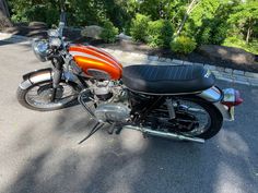 an orange and black motorcycle parked on the street