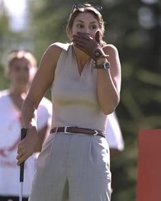 a woman holding a golf club in her right hand