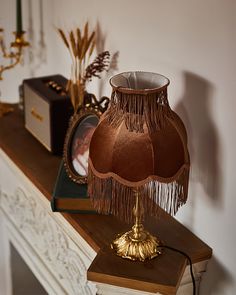 a lamp that is sitting on top of a table next to a clock and other items