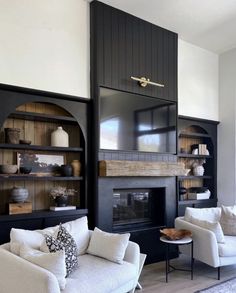 a living room filled with furniture and a fire place in the middle of it's wall