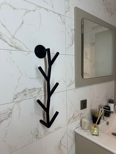 a bathroom with a sink and mirror next to a wall mounted plant on the wall