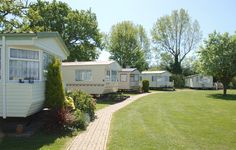 several mobile homes are lined up on the grass