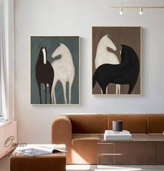 two paintings hang on the wall above a couch