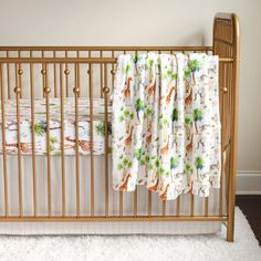 a baby crib with a blanket on top of it and white carpet in front of the crib