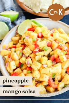 pineapple mango salsa in a bowl with tortilla chips and lime wedges