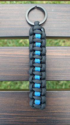 a black and blue paracorine keychain sitting on top of a wooden bench