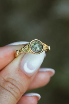 Product Details Ring Style: The "Selene" is an accented-style moss agate women's engagement ring. Many other center stone options are available upon request. Center Stone: 7mm Round Cut Moss Agate Materials: 14K gold engagement ring featuring a moss agate center stone Customizable: Because each ring is handcrafted to order, we can customize yours using unique materials, gemstones, or design features, often without any added cost! We can even use personal materials that you send! Basic ... Untraditional Unique Engagement Rings, Bohemian Wedding Rings Melanie Casey Fine Jewelry, Vintage Nature Engagement Ring, Non Conflict Engagement Rings, Non Traditional Engagement Rings Inexpensive, Simple Unique Vintage Engagement Rings, Unique Wedding Rings Modality, Creative Engagement Rings Vintage, Unique Wedding Rings Hippie