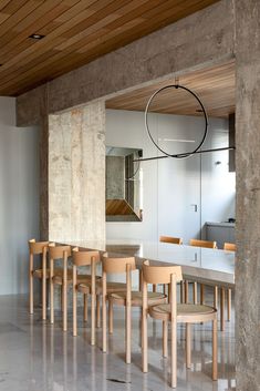 a dining room table with six chairs and a circular light fixture hanging from the ceiling