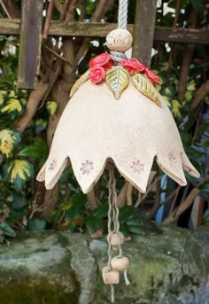 a bell hanging from a rope with flowers on it