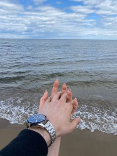 a person holding the hand of another person at the beach