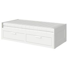 a white bed with two drawers on the bottom and one drawer open to show it's mattress