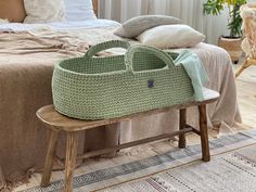 a basket sitting on top of a wooden bench next to a bed