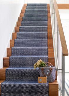 a blue carpeted stair case with a basket on it