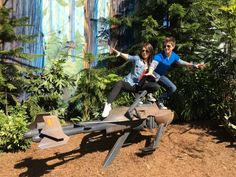 two people on a bench in front of some trees